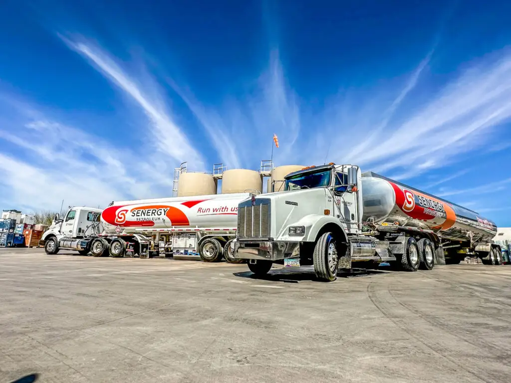Senergy Petroleum branded fuel tanker trucks parked at a fuel storage facility
